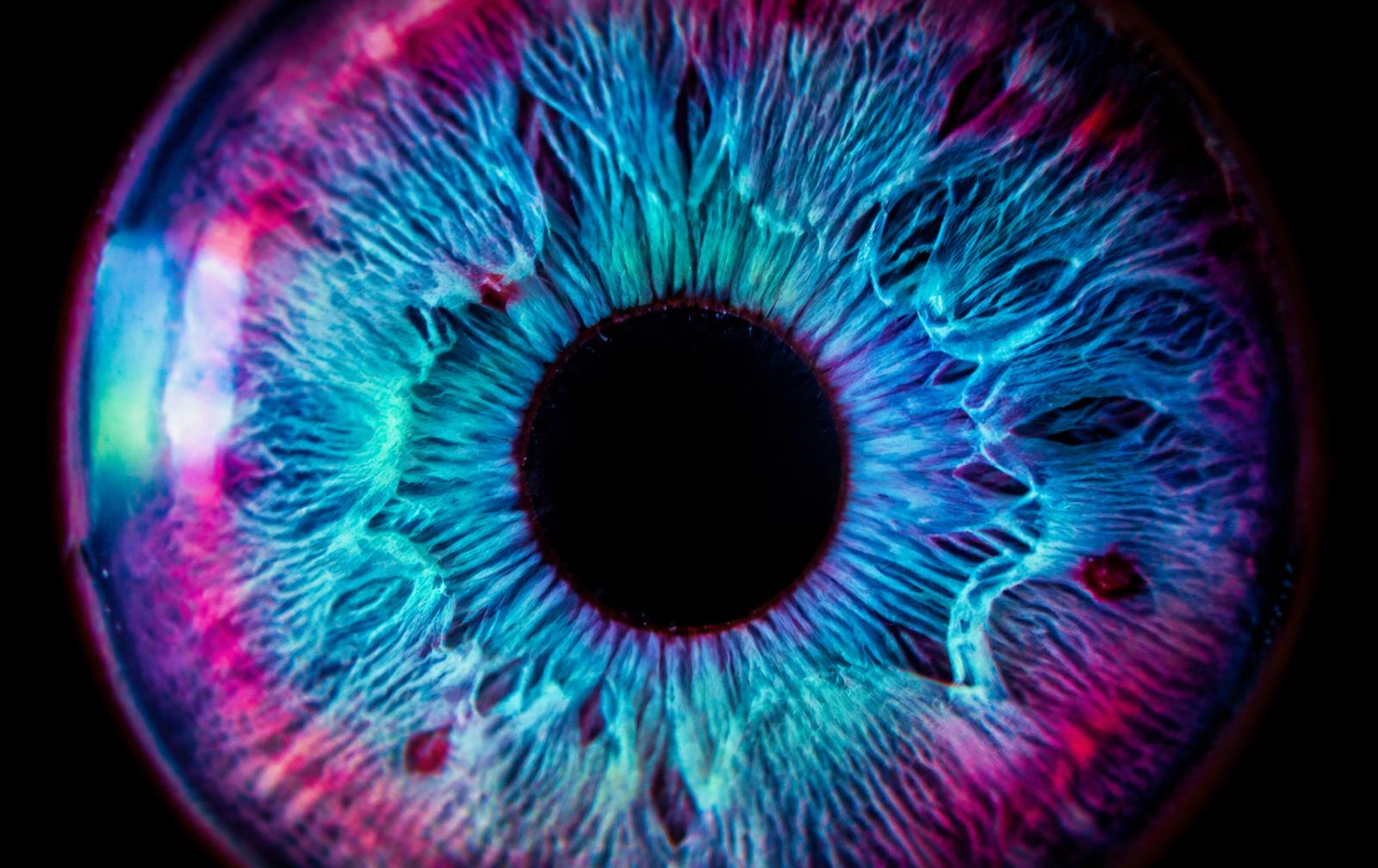 Macro de un iris humano con tonos cian y magenta